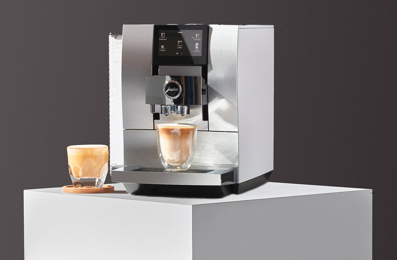Jura Z10 superautomatic espresso machine brewing a latte macchiato on a countertop